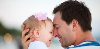 Beautiful baby girl and father, smiling nose to nose.
