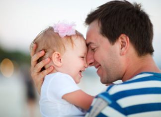 Beautiful baby girl and father, smiling nose to nose.