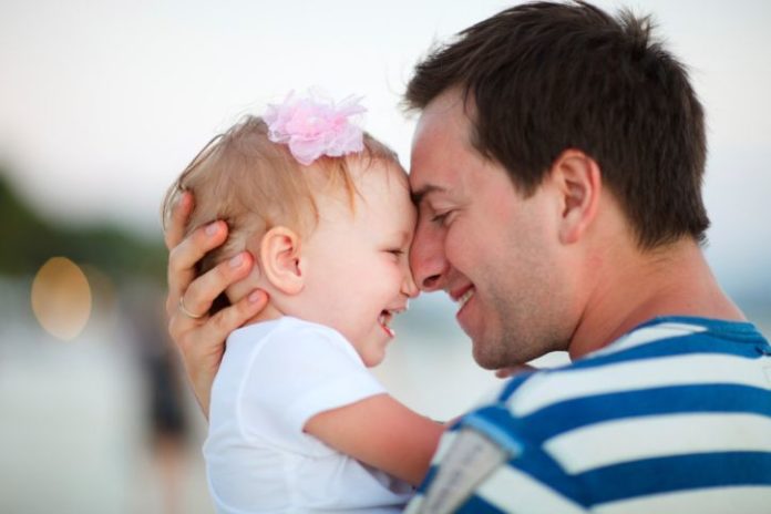 Beautiful baby girl and father, smiling nose to nose.