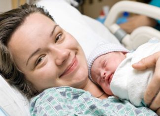 A happy mother in a hospital bed with newborn baby.