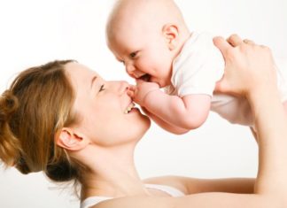 A mother lifts her baby above her head.