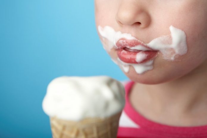 Child with ice cream all over face.