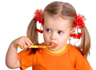 Girl with long pigtails brushing teeth.