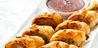 Sausage rolls on a tray with dipping sauce.