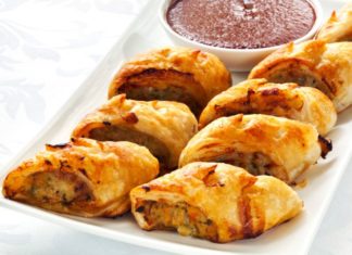 Sausage rolls on a tray with dipping sauce.