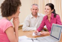 Couple talking with doctor in office.