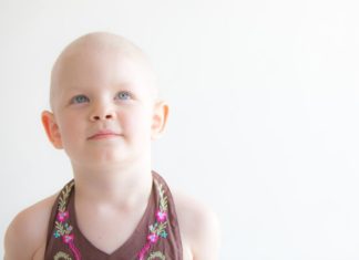 A bald little girl looking angelic.