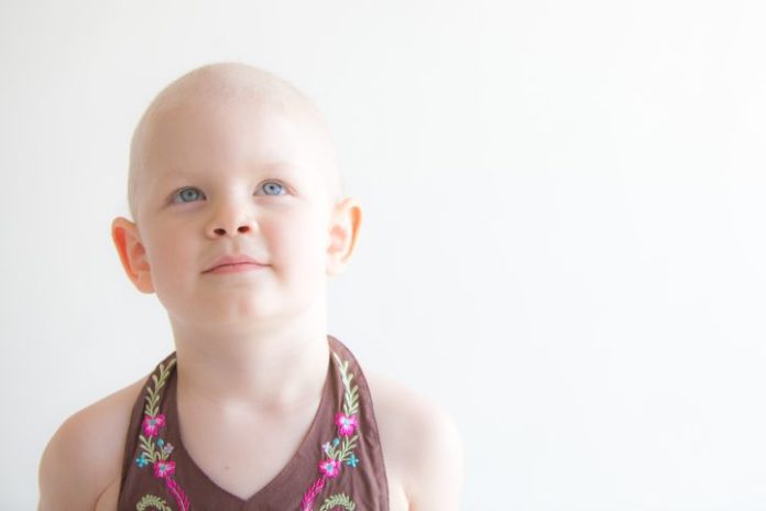 A bald little girl looking angelic.