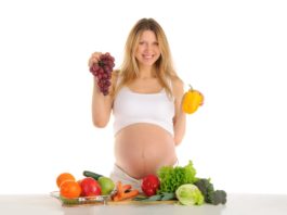 Happy pregnant woman with fruits and vegetables