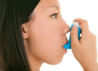 Teen takes her inhaler.