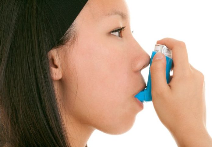 Teen takes her inhaler.