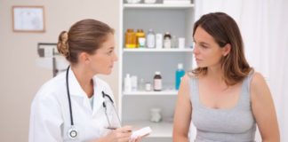 Woman talks with female doctor. Doctor takes notes.