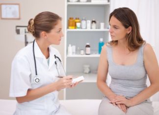 Woman talks with female doctor. Doctor takes notes.