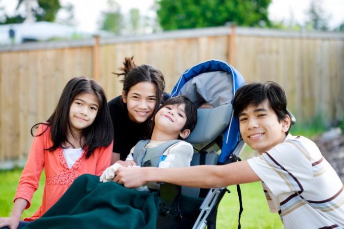 Child in wheelchair with family