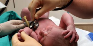 Doctor examining newborn