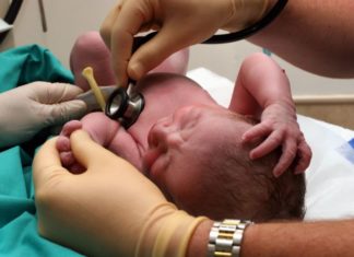 Doctor examining newborn