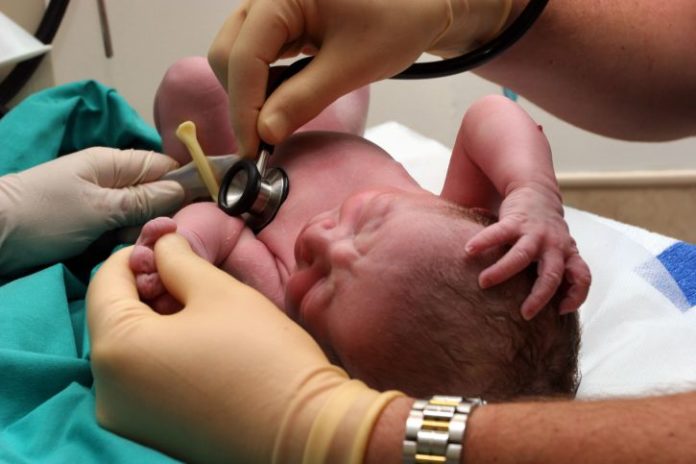 Doctor examining newborn