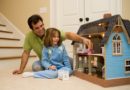 Dad and daughter play with doll house