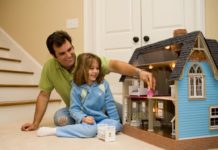 Dad and daughter play with doll house