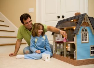 Dad and daughter play with doll house