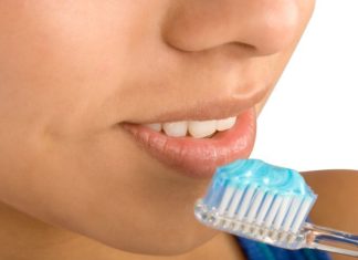 A close up of a face and toothbrush.