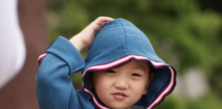 Little boy scratching his head