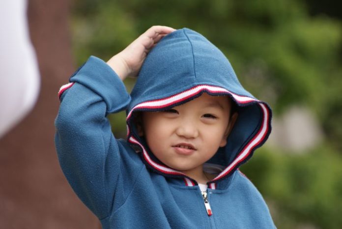 Little boy scratching his head