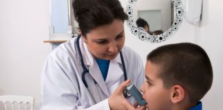 Doctor giving boy inhaler