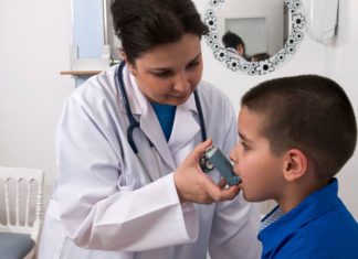 Doctor giving boy inhaler
