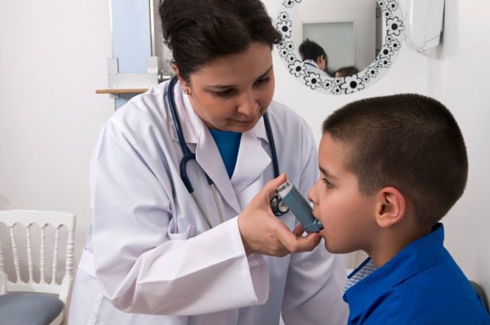 Doctor giving boy inhaler