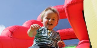 Child on inflatable bouncy castle slide