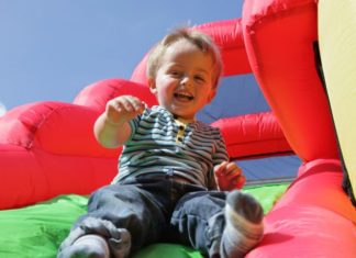 Child on inflatable bouncy castle slide