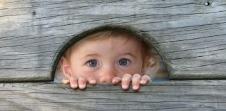 Child peeking through hole