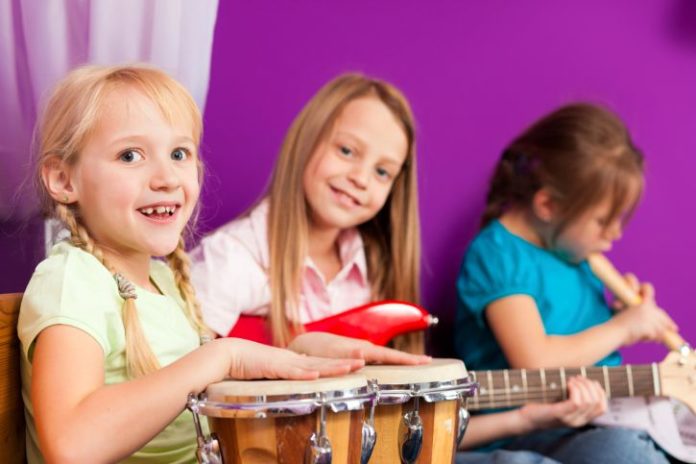 Drums, guitar, recorder and girls playing.