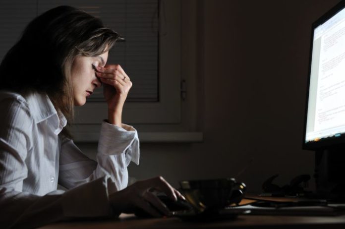 Woman working late, tired and stressed