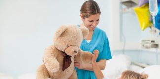 Nurse showing a teddy bear to child