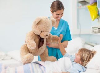 Nurse showing a teddy bear to child