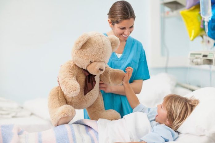 Nurse showing a teddy bear to child