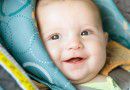 Happy baby buckled into rear-facing car seat