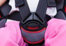 Girl sitting at carseat and fasten seat belt