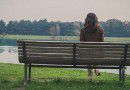 Young woman sitting on a bench in a city park