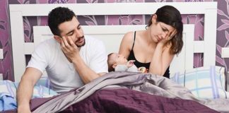 exhausted parents with newborn baby