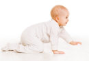 baby-crawling-white-onesie-warm-whitebackground