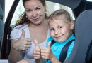 Mother and child showing thumb up gesture in car seat