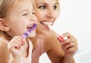 Mother And Daughter Brushing Teeth Together