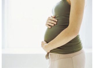 Pregnant woman holding stomach.