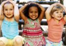 Close-up of three girls sitting and smiling