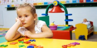 An unhappy girl in a classroom setting.