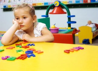 An unhappy girl in a classroom setting.