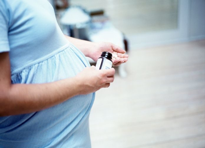 Pregnant woman taking tablets